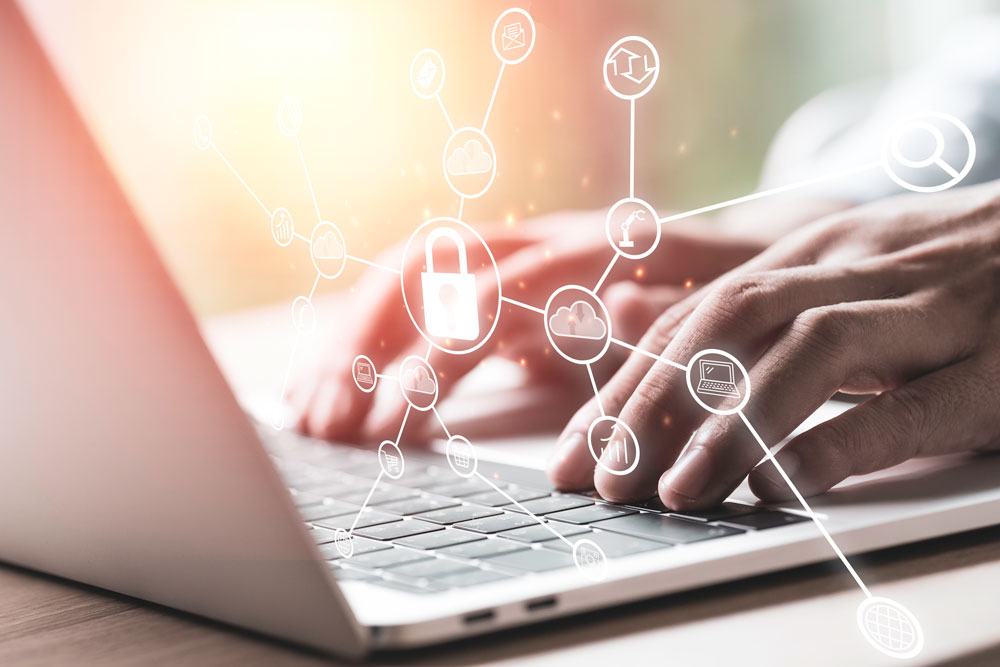Photo of office worker typing on laptop with graphics of technology and security icons