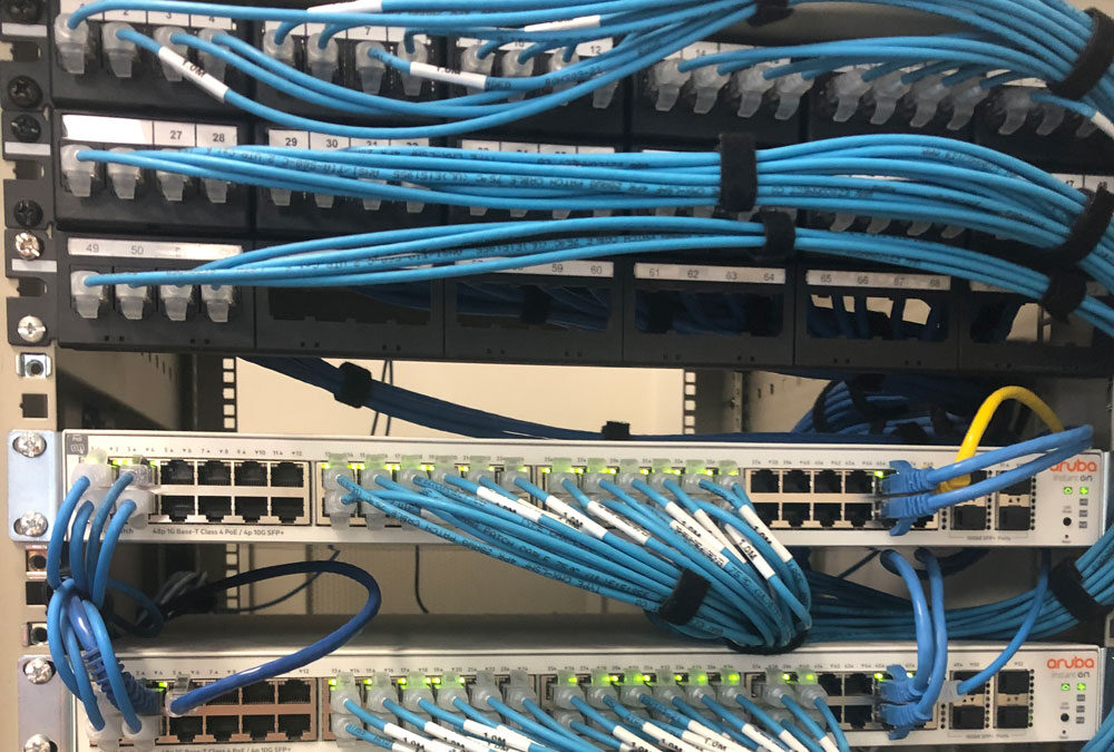 Photo of ethernet cables connected to Aruba switches