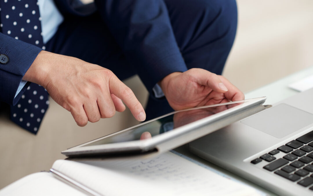 Business professional using tablet and laptop