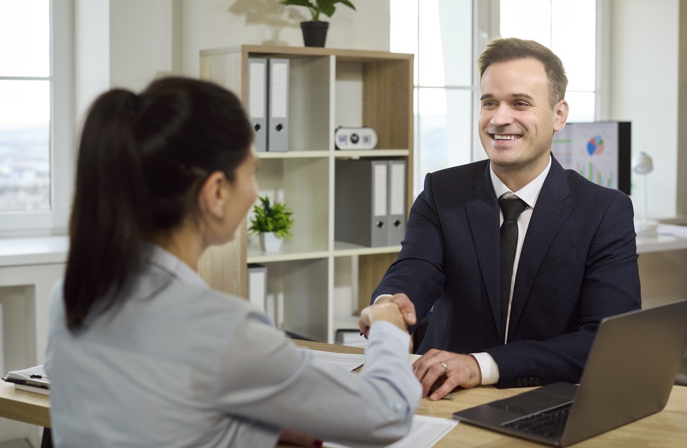Banker,And,Client,Handshake,After,Loan,Approval.,Smiling,Manager,Closes